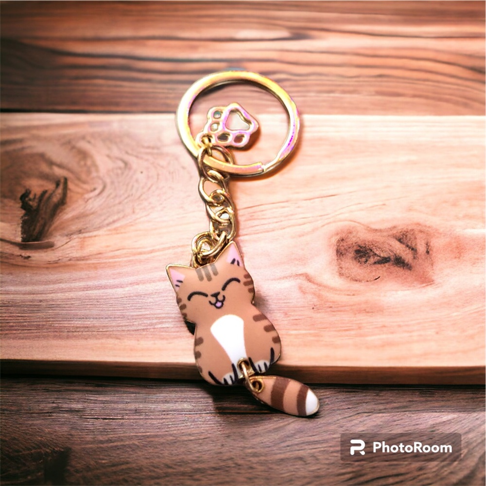 Cat charm.  Brown cat with white belly & closed eyes.
